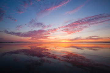 Colorful beautiful cloudy sunset over ocean surface