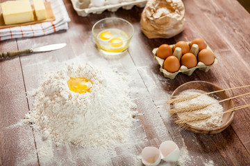Egg yolk in flour on a wooden table in a bakery. Rural or rustic style.