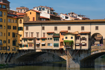 River Arno and famous bridge Ponte Vecchio (The Old Bridge) at sunny summer day. Florence, Tuscany, Italy