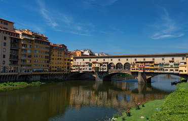 River Arno and famous bridge Ponte Vecchio (The Old Bridge) at sunny summer day. Florence, Tuscany, Italy