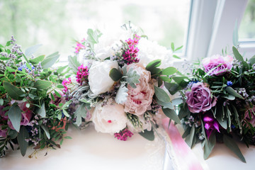 Wedding bouquets lie on white windowsill