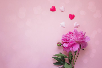 Romantic background with peony and hearts on pink. Copy space