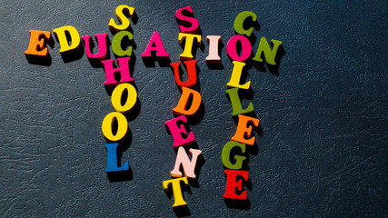 The words Education, School, Student, College built of colorful wooden letters on a dark table.