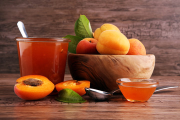 Apricot jam in glass bowl with fruit around