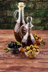 Bottle virgin olive oil and oil in a bowl with some olives