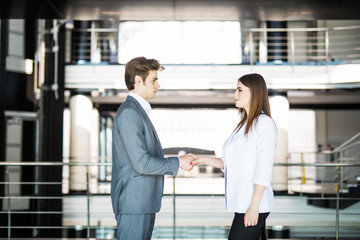 Business handshake - two businesspeople shaking hands to conclude deal or agreement. Business concept