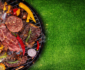 Top view of fresh meat and vegetable on grill placed on grass