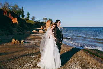 Groom and bride on a walk outdoors at the sea