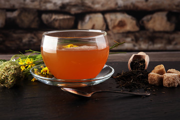 A cup of tea with tea leaves. Tea among the herbs.