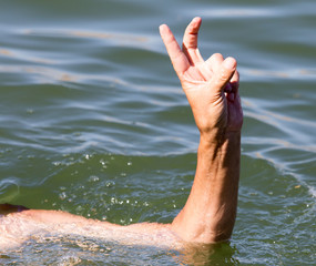 Man's hand on the water in the pool