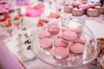 Pink macaroons served under glass cover