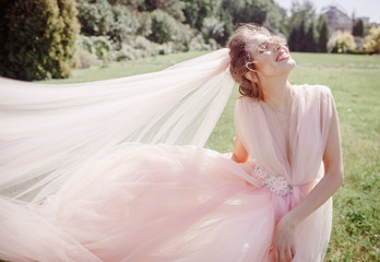 Fototapeta na wymiar Beautiful bride whirls her wedding dress posing on the backyard