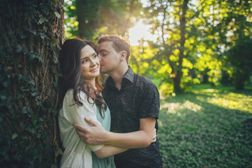 Fototapeta premium Cute couple kissing in the park on a sunny day