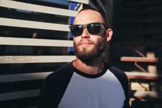 Hipster man wearing black sunglasses in urban city streets