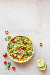 Bowl of guacamole dip  with ingredients. Rustic background, top view, lots of copy space
