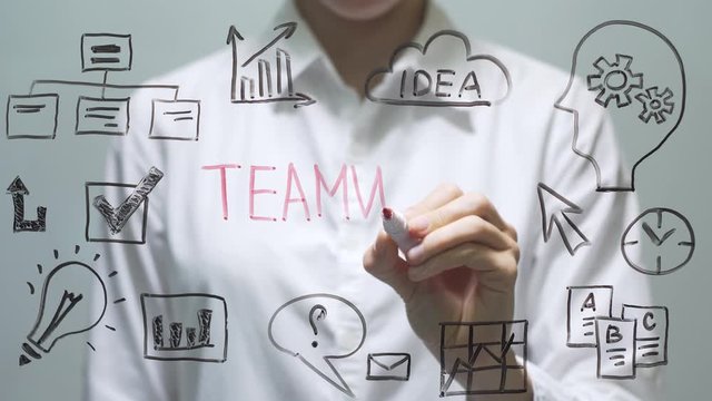 Woman writing TEAMWORK on transparent screen. Businesswoman write on board.
