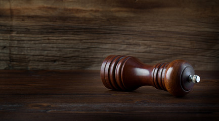 Pepper mill on a wooden background