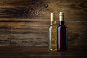 A bottle of red and white wine on a wooden background