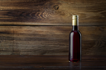 Fototapeta na wymiar A bottle of red wine on a wooden background