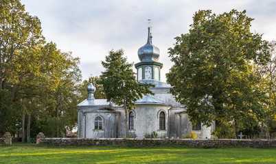Old white stone orthodox church among trees