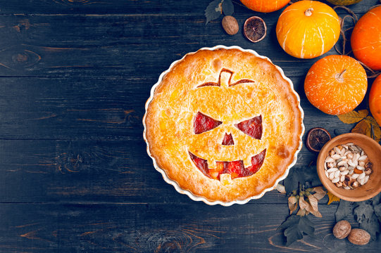 Delicious homemade pie for halloween with a filling of pumpkin-strawberry jam and peaches