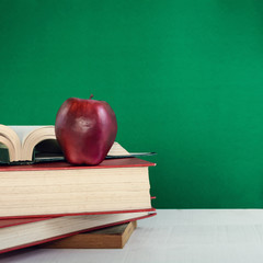 Books Pencil and apple on a white wooden table