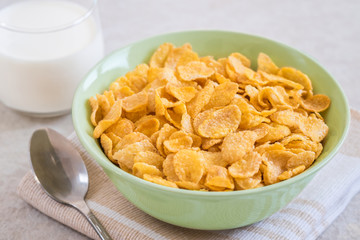 Corn flakes in bowl and milk glass