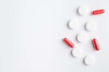 Red and white pills on white background