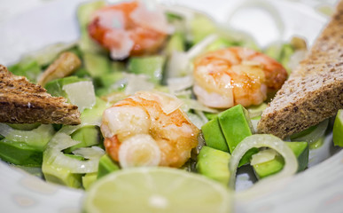 Salad of Avocado, fruit like butter, olive oil, onion, garlic, plate, prawn