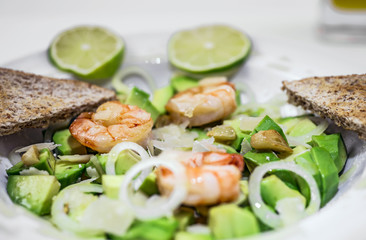 Salad of Avocado, fruit like butter, olive oil, onion, garlic, plate, prawn