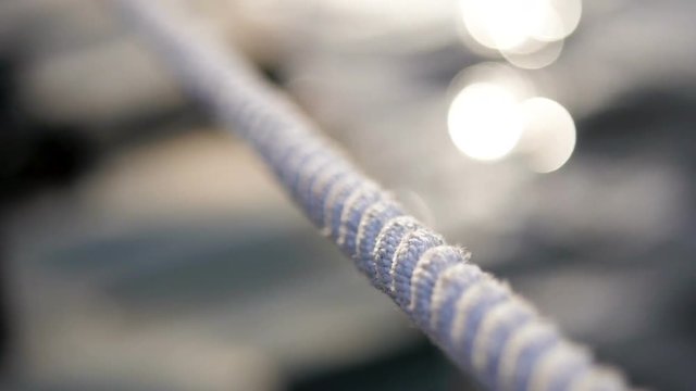 Detail of nautical rope with blurry water in the background