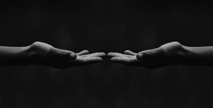 A Panoramic Black And White Close Up Of Hands Almost Touching