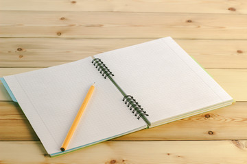 pencil on notebook with bookmarks lying on a wooden table