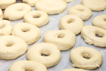 Raw dough donuts prepared on the table ready for frying