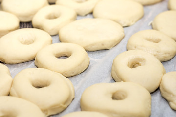 Closeup macro raw domestic homemade dough donuts prepared on the table ready for frying