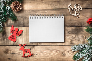 Blank paper notebook on brown wooden table background. Top view with copy space.