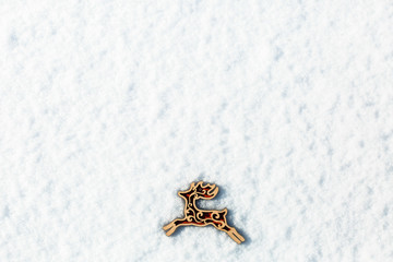 Red wooden toy deer in the snow