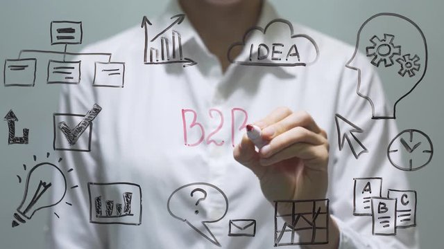 Woman writing B2B on transparent screen. Businesswoman write on board.