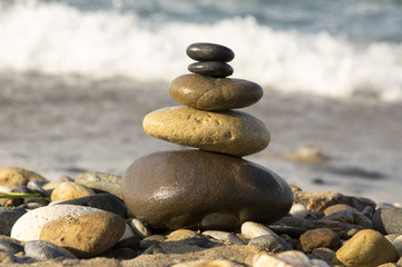 Fototapeta na wymiar Harmony and balance, poise stones against the sea, rock zen sculpture, sunny day
