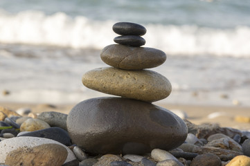 Obraz na płótnie Canvas Harmony and balance, zen cairn on pebble beach, sea waves on background