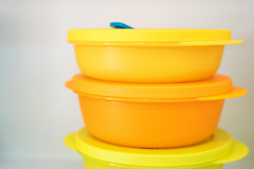 Group of yellow plastic food containers on shelf