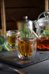 cup of tea in sunny morning. green fresh leaves on the table