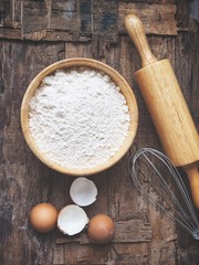 Baking flour with rolling pin and whisk eggs