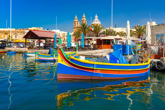 Fototapeta Traditional eyed colorful boats Luzzu in the Harbor of Mediterranean fishing village Marsaxlokk, Malta