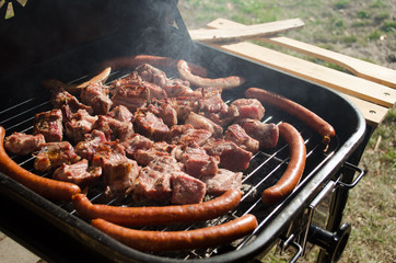 Grilling meat and sausages on barbecue grill.