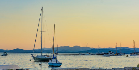 sails boats moored in lake at dusk in the evening
