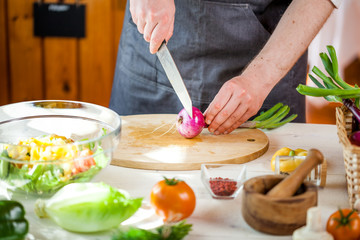Chef cutting fresh and delicious vegetables for salad