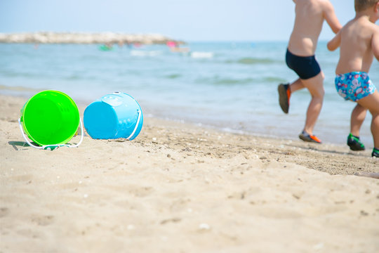 kids playing with beach toys on the beach in summer