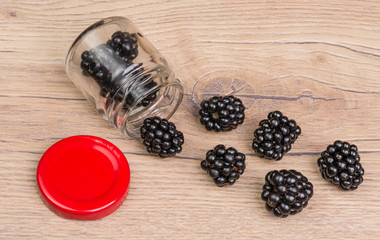 Spilled blackberries on a garden table. Delicious fresh snack on a wooden background.