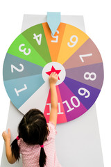 Asian girl trying to spin the huge colorful fortune wheel with white digit numbers
